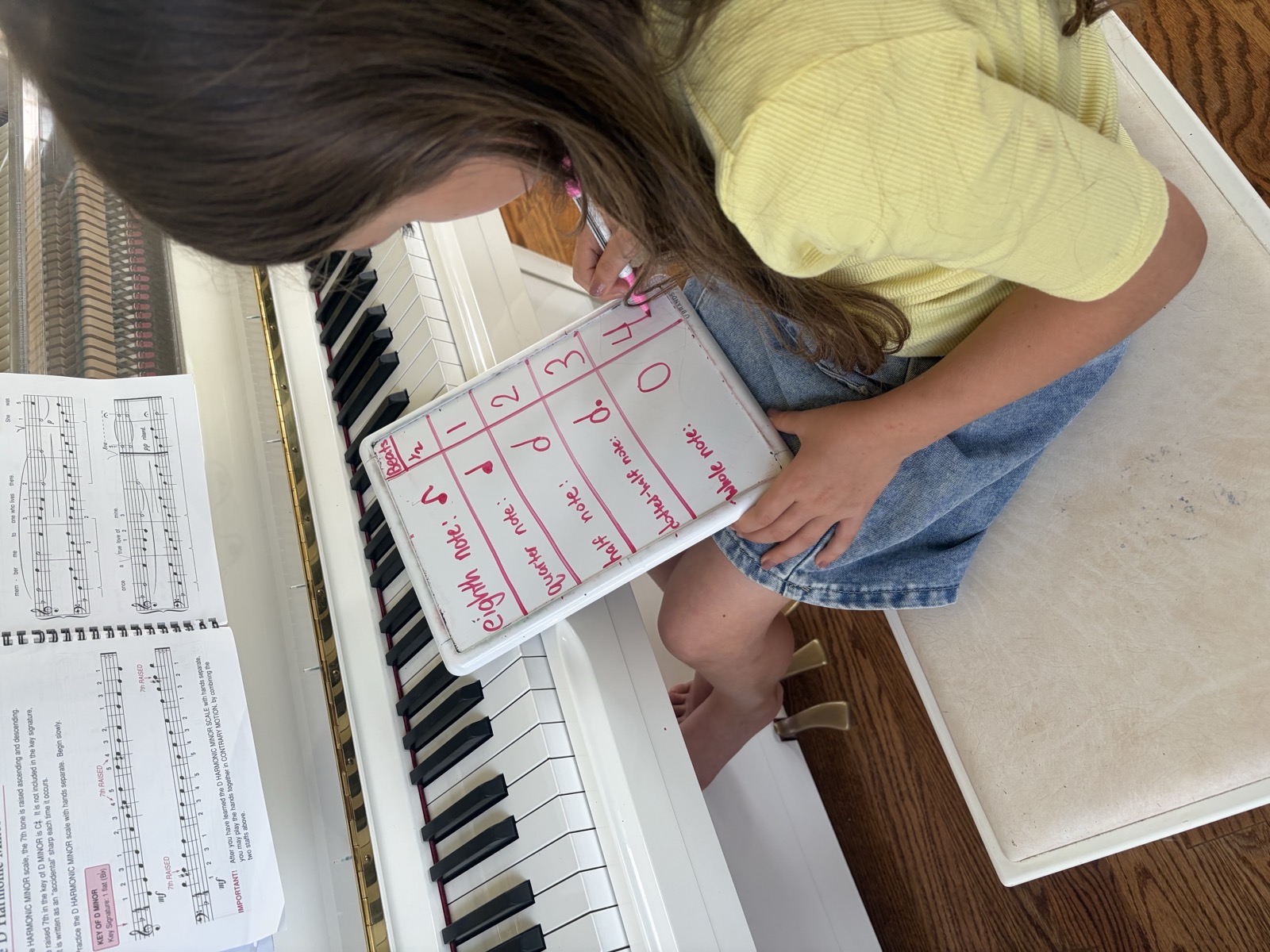 Student writing note values at the piano